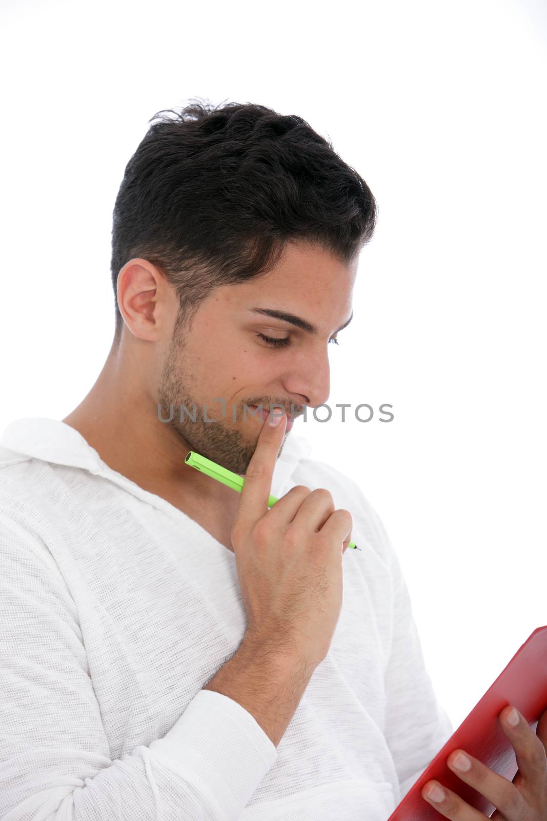 Thoughtful man reading from a clipboard standing concentrating with his hand to his chin, isolated on white
