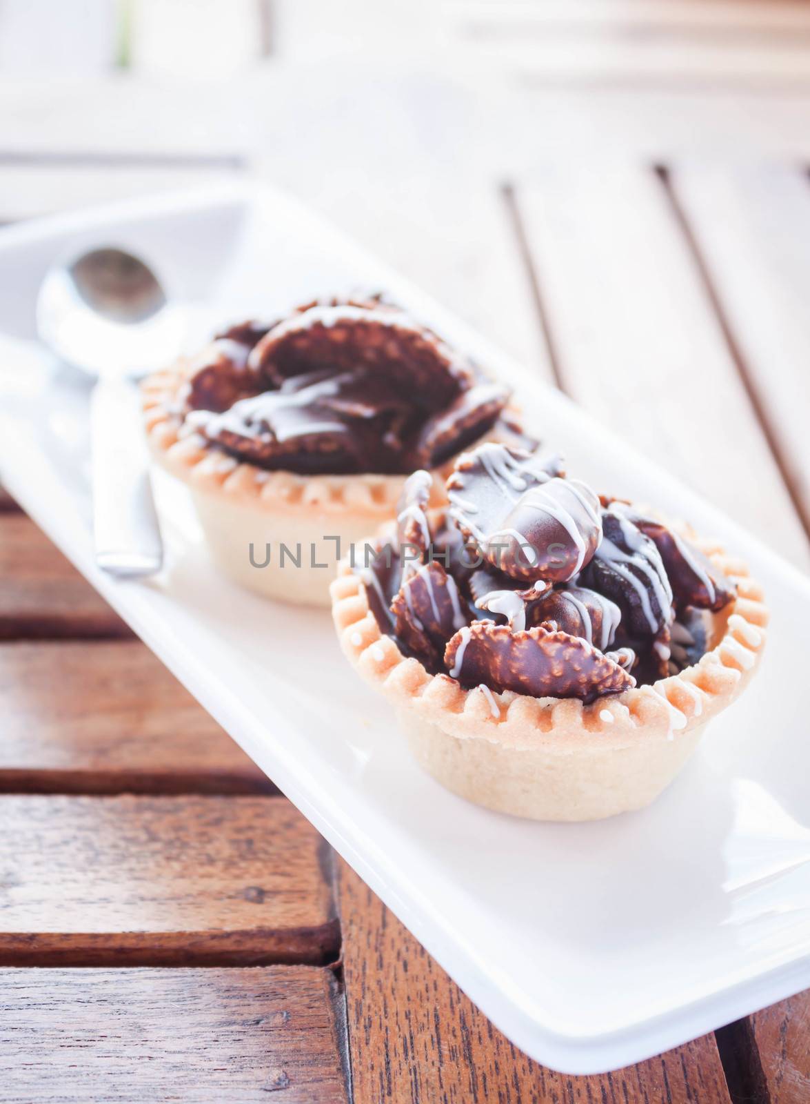 Crispy chocolate tarts on wood table, stock photo