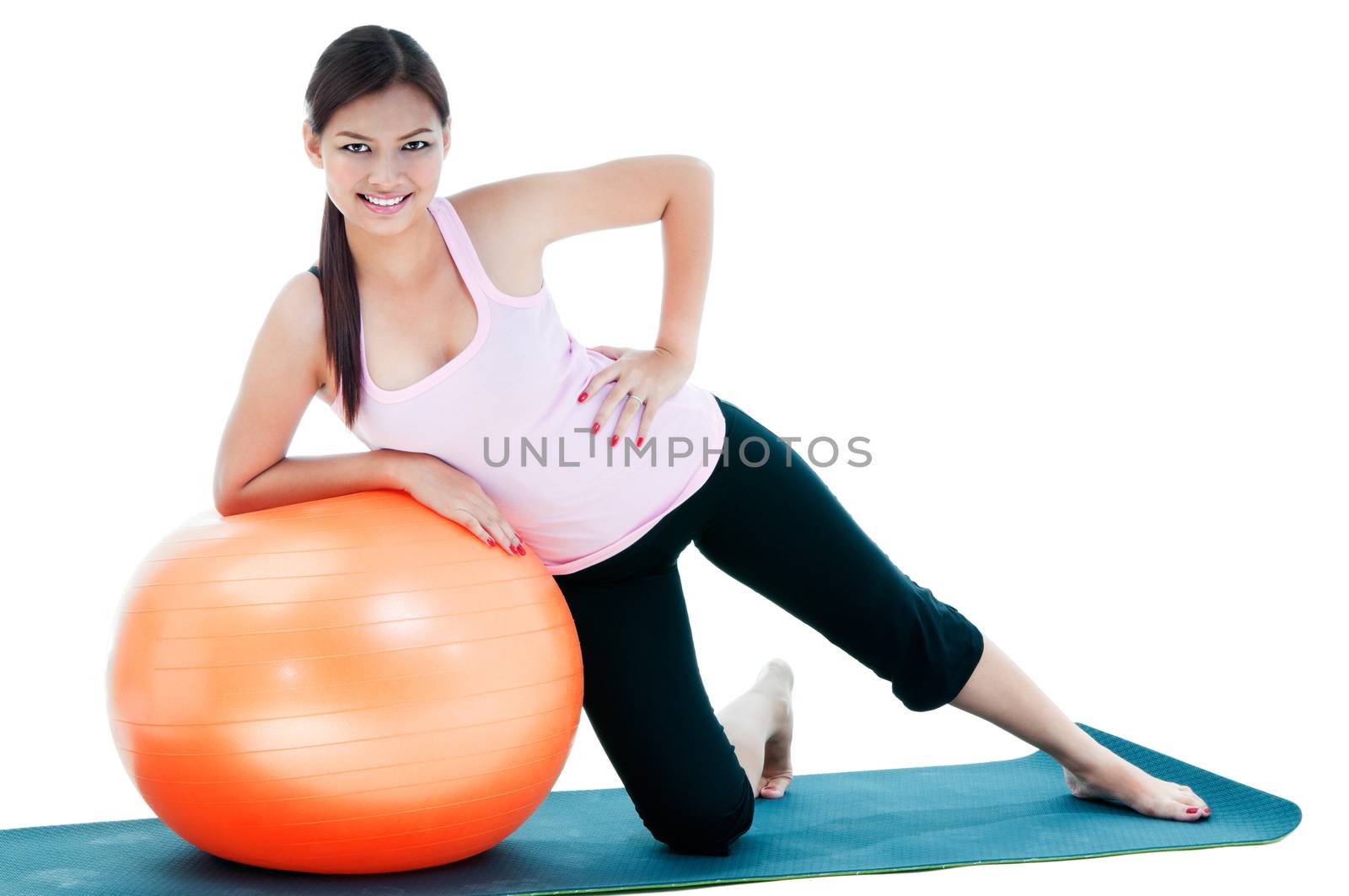 Portrait of pretty young woman doing exercise on balance ball.