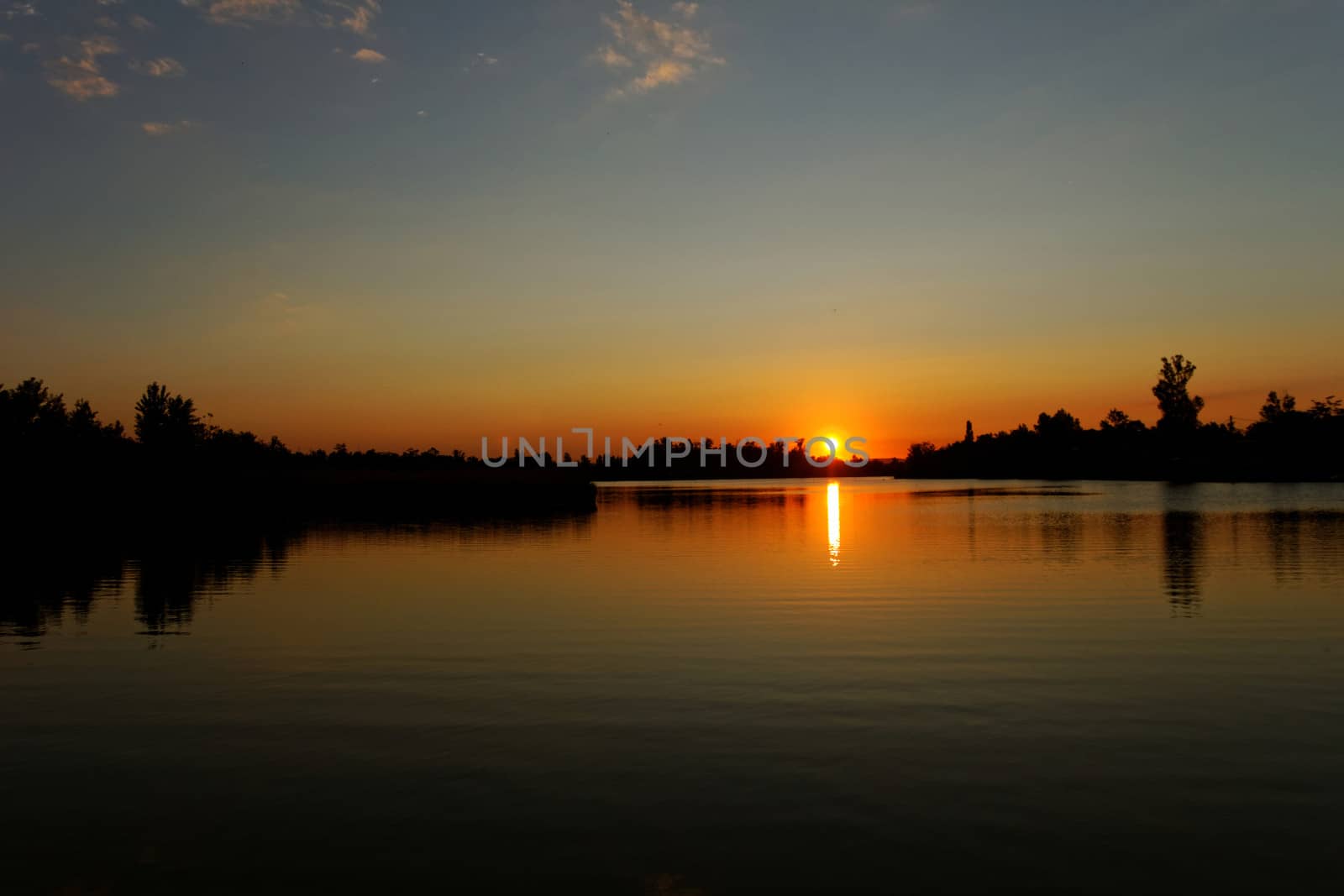 Colorful sunset over tranquil water surface.