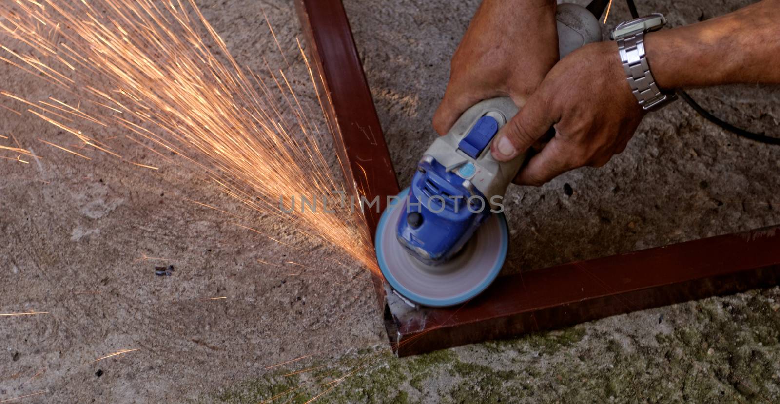 Metal buffing with hand grinder. Sparks while grinding iron.