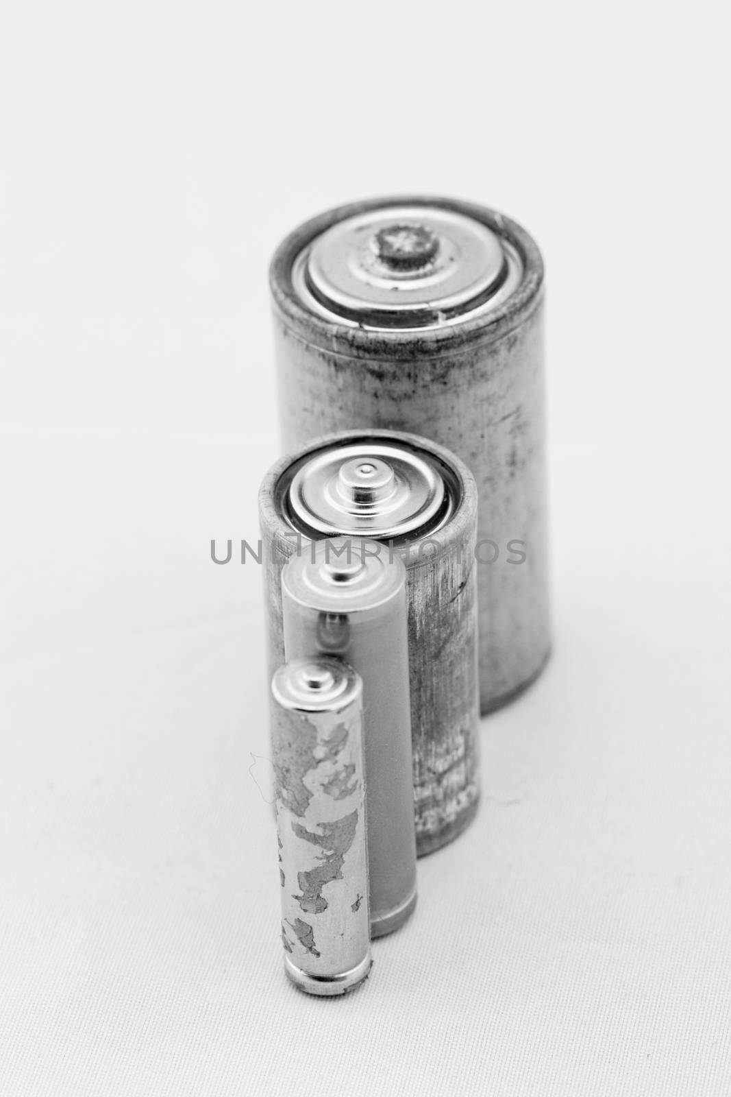Old grey batteries on white background (aa, aaa, b, c)