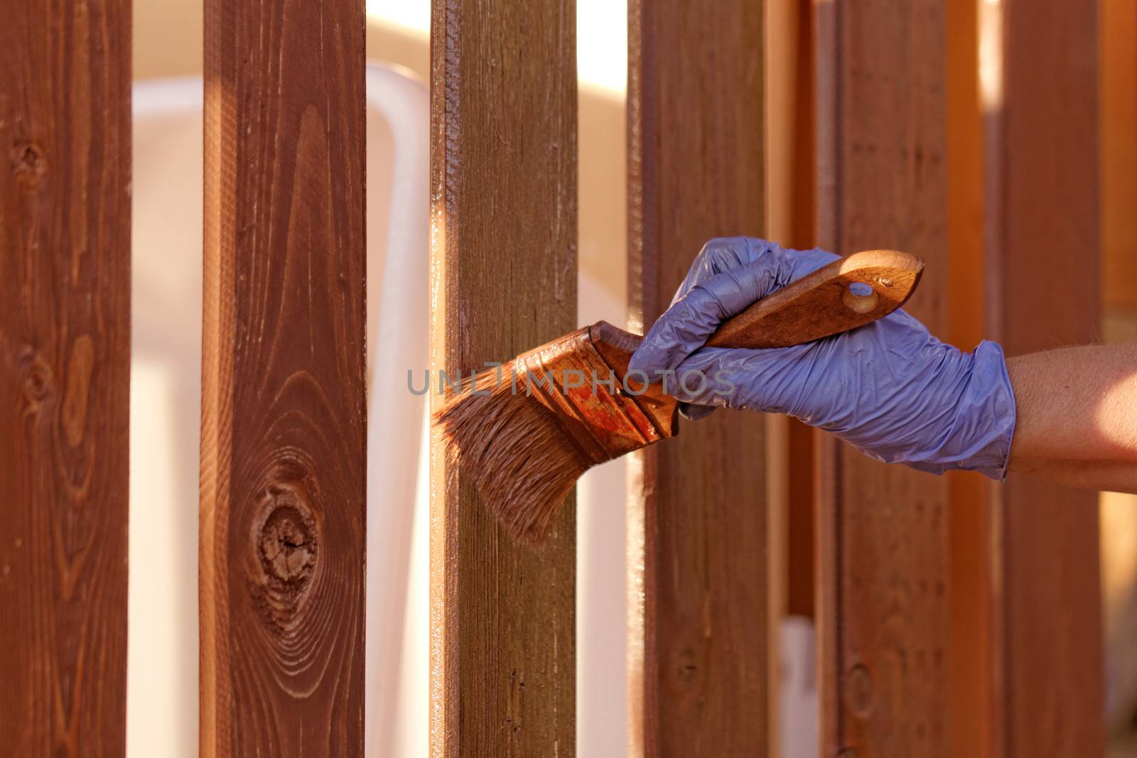 planks fence dyeing with brown paint and brush