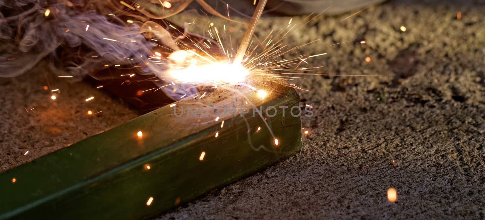 Iron welding with bright light and smoke at manufacturing