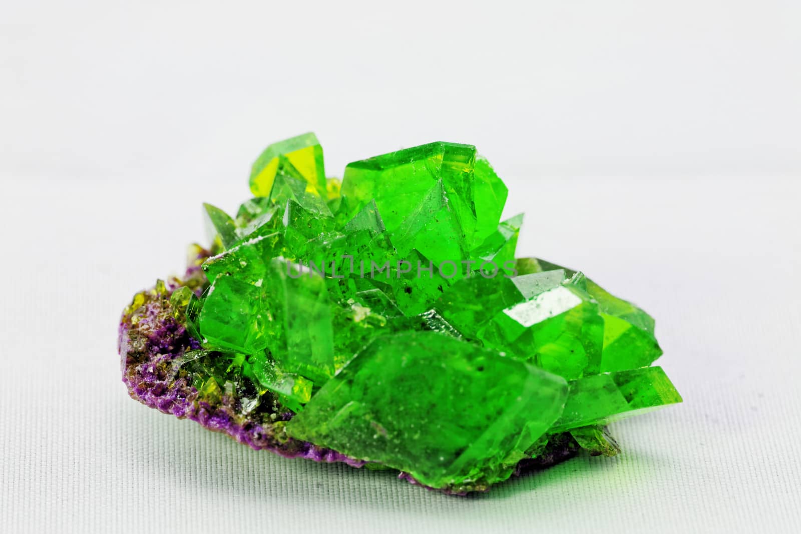 Close up picture about a crystal with emerald color on white background (green crystal)