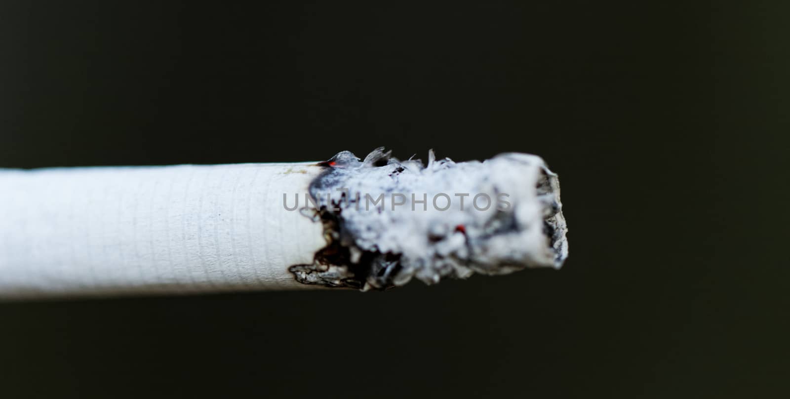 Smoking a cigarette against a dark background