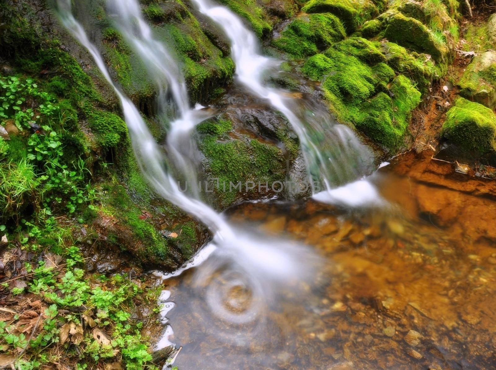 Beautiful waterfall falling over rocks in a small lake