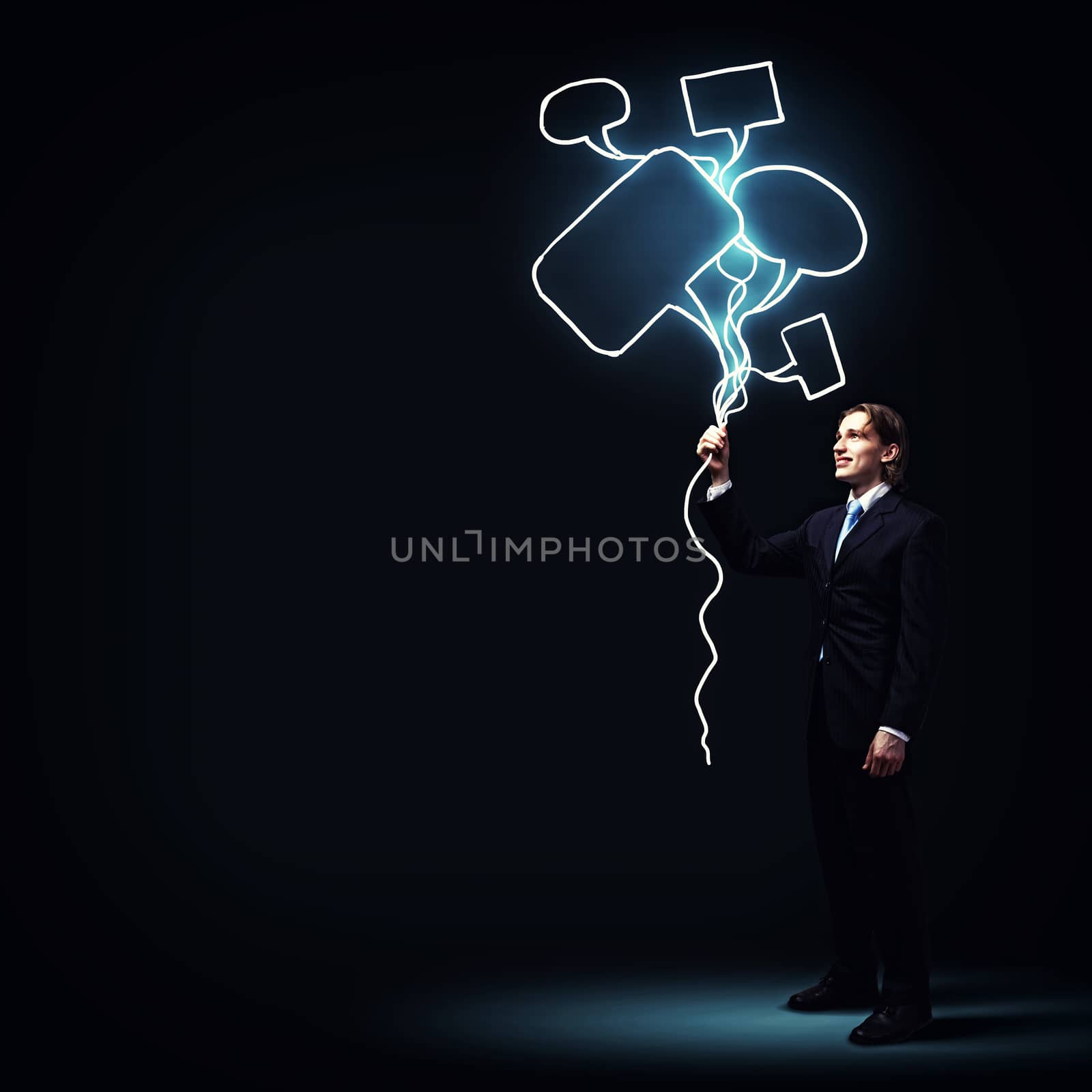 Image of businessman in black suit against dark background