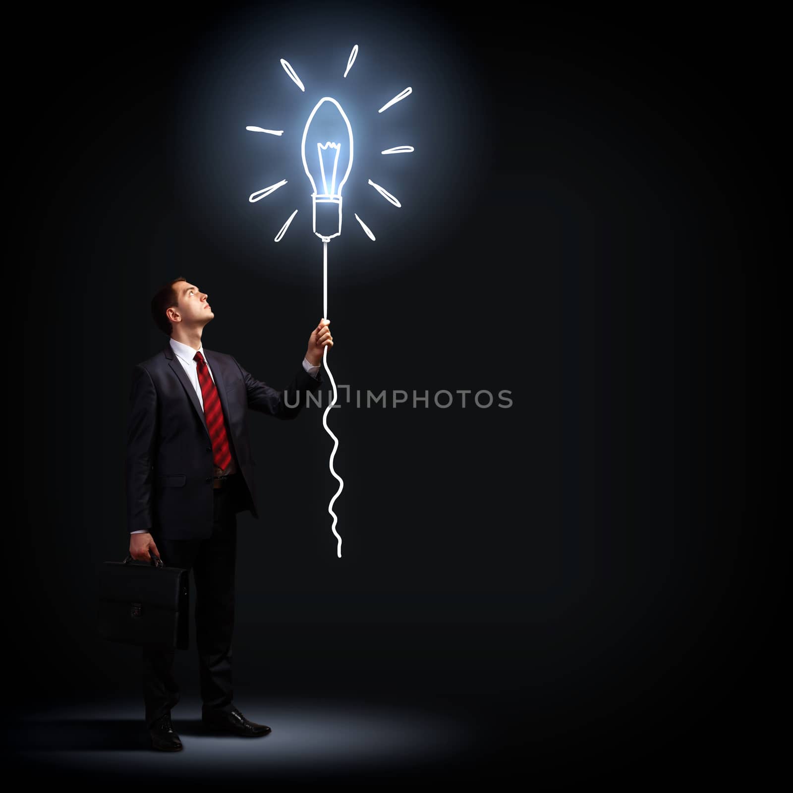 Image of businessman in black suit against dark background