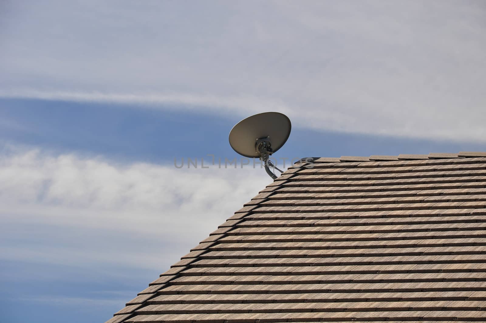 View of a roof-mounted satellite dish aimed upward toward the southern sky.