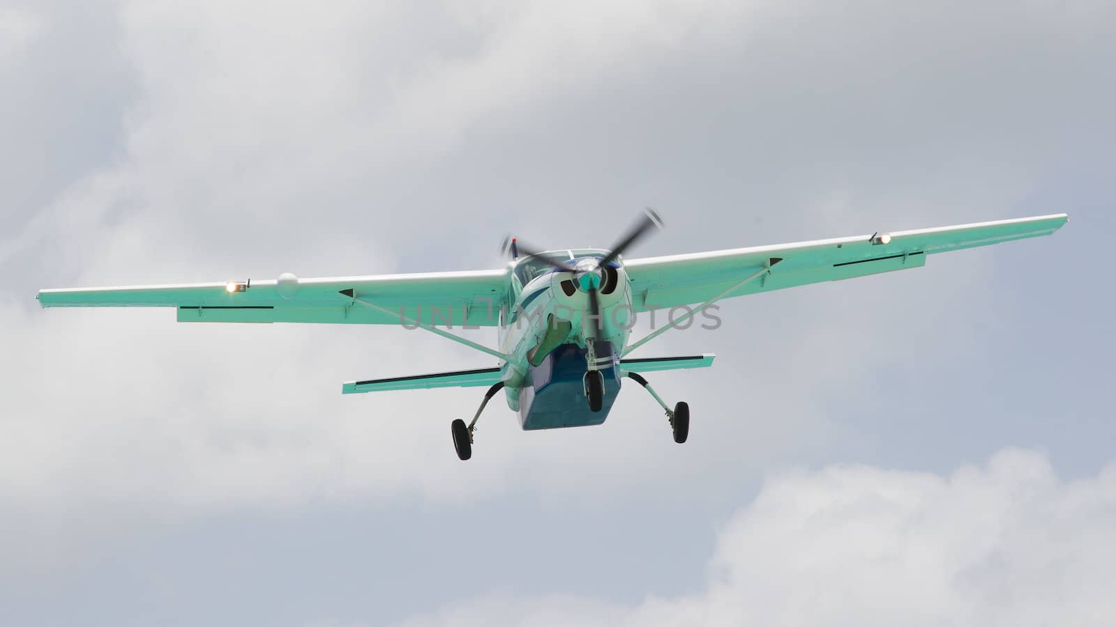 Small plane descending against a cloudy sky