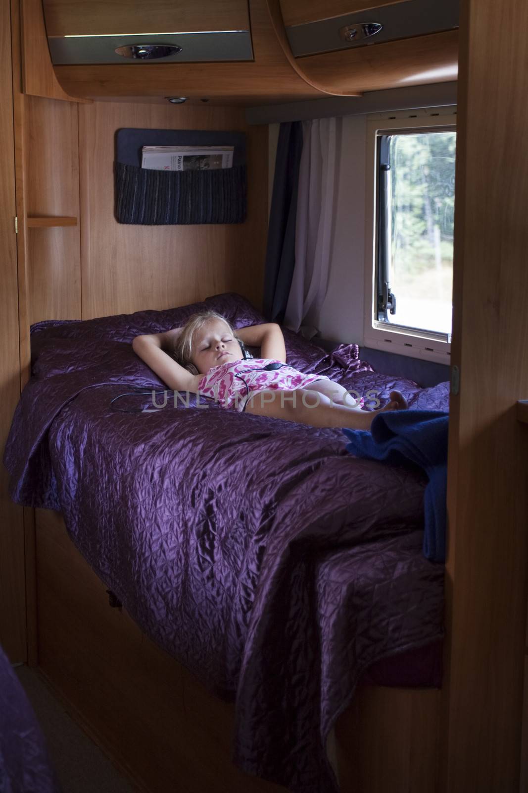 A girl sleeping in a bunk bed inside a moving trailer
