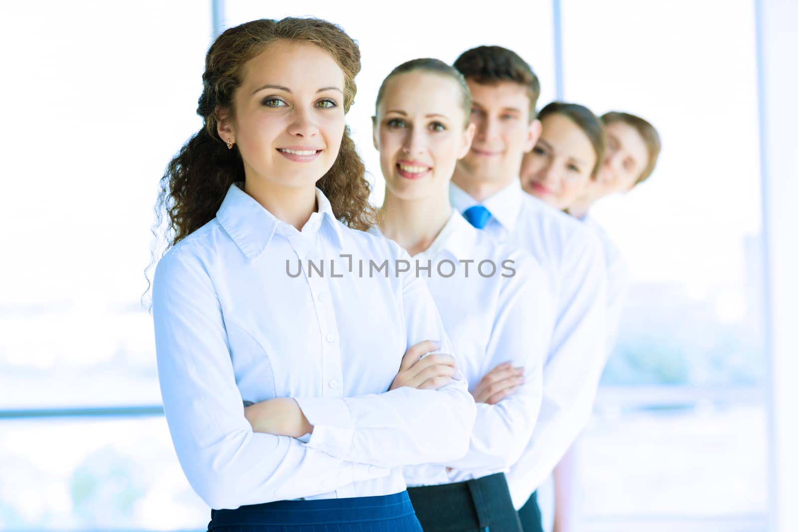 portrait of a young business woman standing in line with colleagues, concept of teamwork