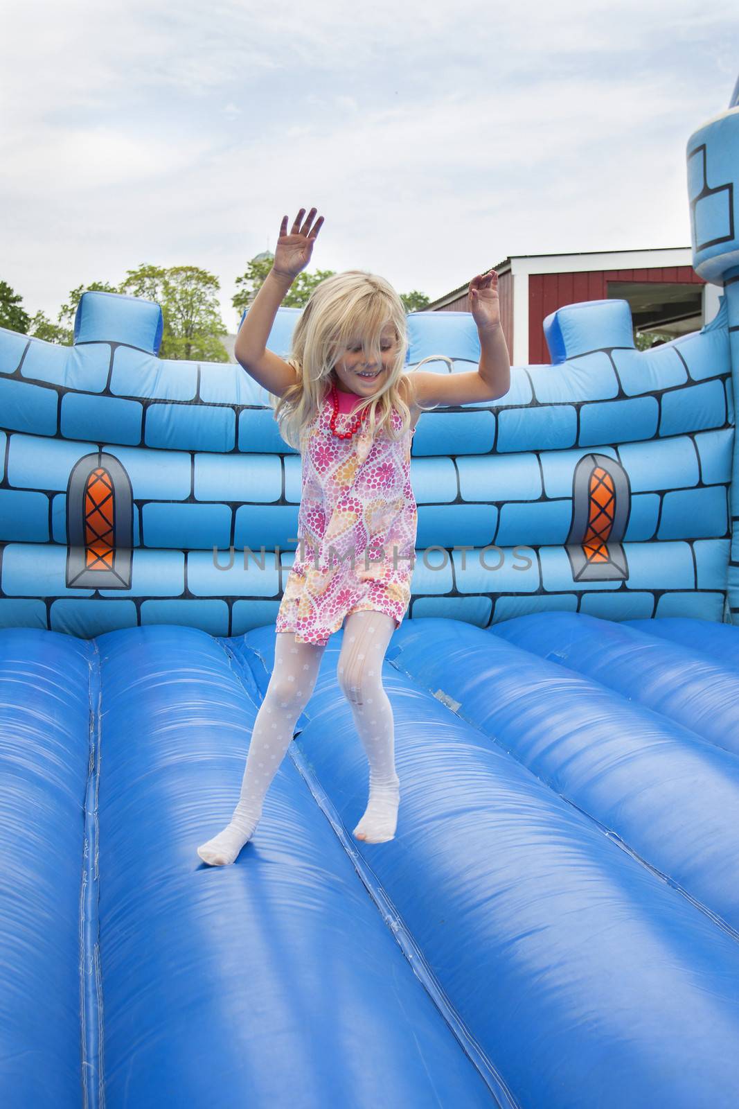 A 6 year old girl having fun on a bouncy mat