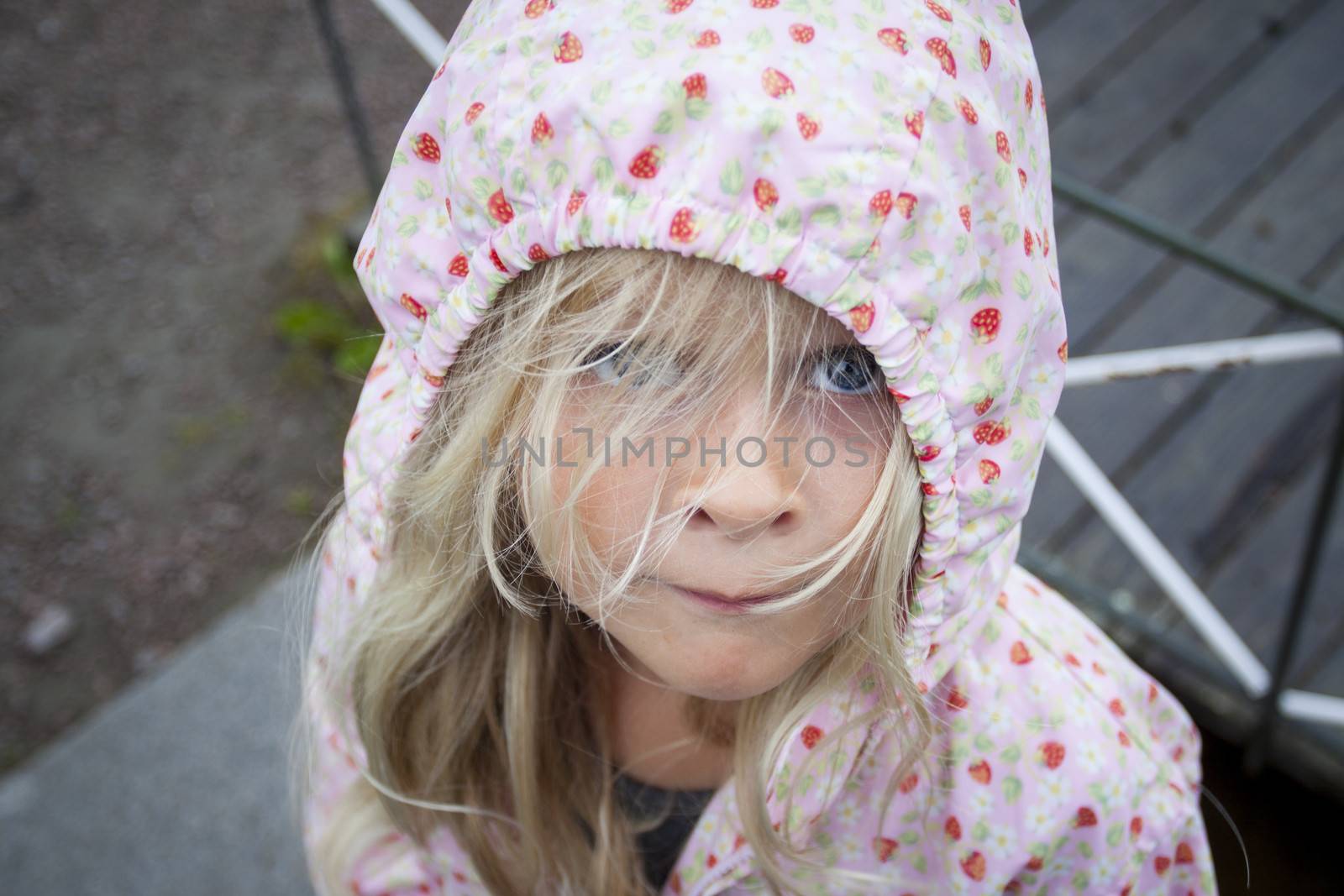 A child standing in the rain looking at camera