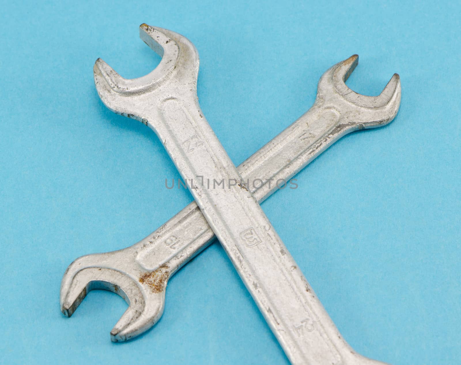 two different size screw spanners wrench hand tools on blue background.