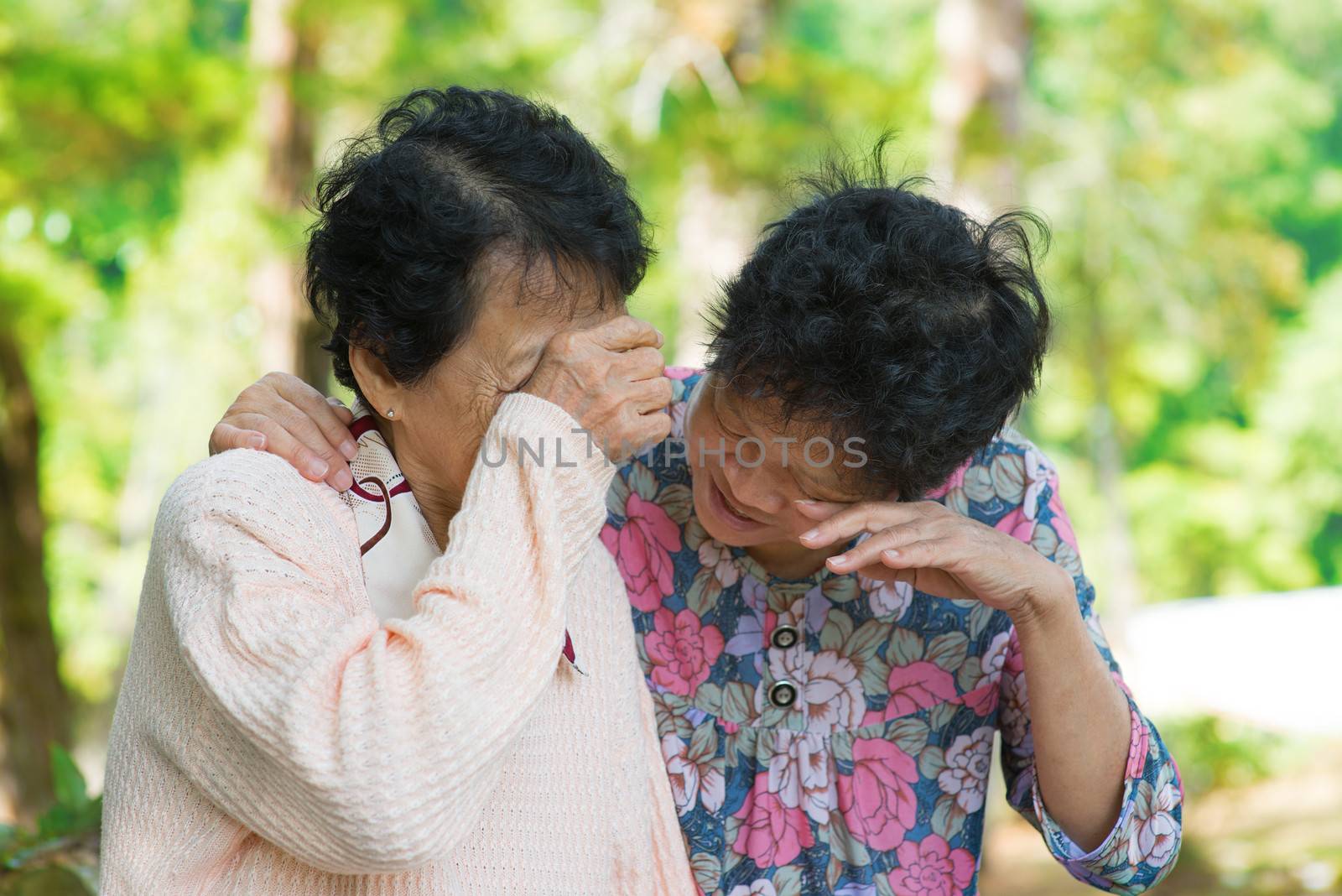 Sad senior Asian women  in grieving the loss of a loved one. Outdoor park.