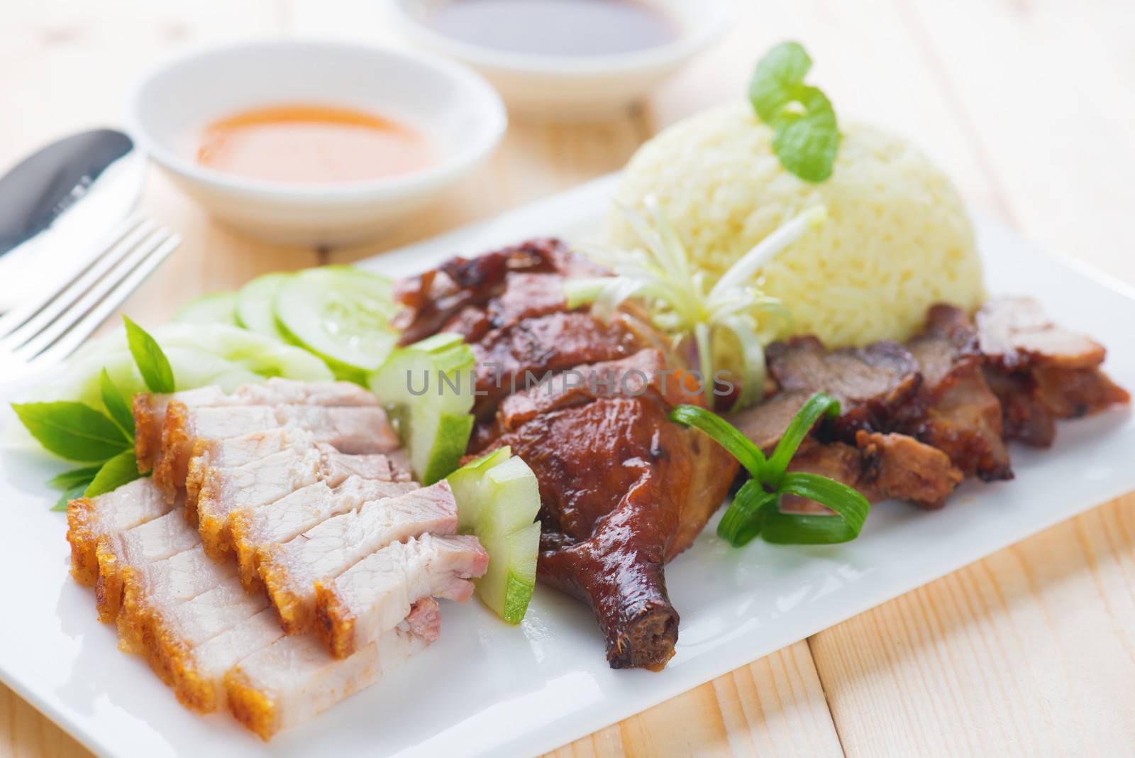 Roasted duck, roasted pork crispy siu yuk and Charsiu Chinese style, served with steamed rice on dining table. Malaysia cuisine.