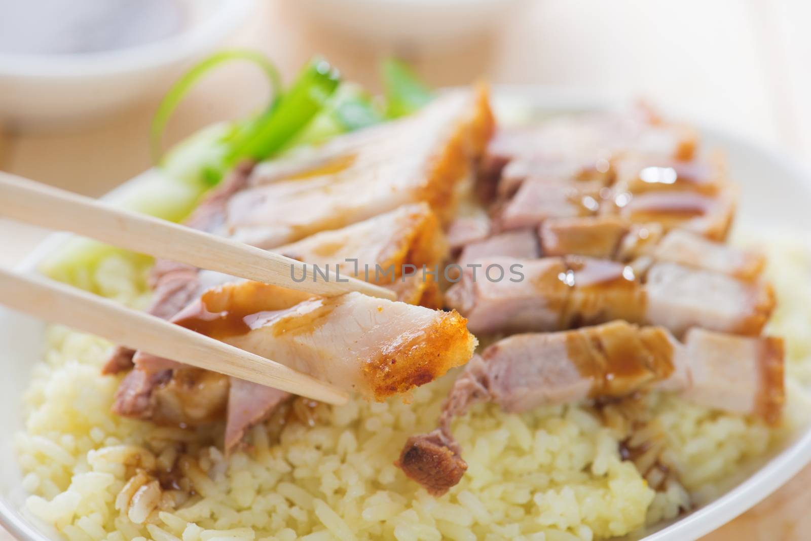 Siu Yuk - Chinese roasted pork served with soy and hoisin sauce. Hong Kong cuisine. Close up on meat and chopsticks.