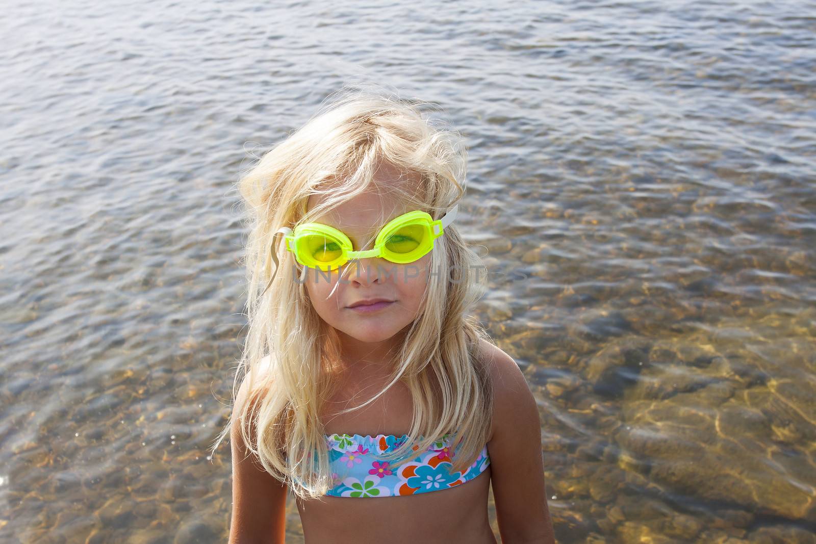A little girl with yellow goggles looking at camera