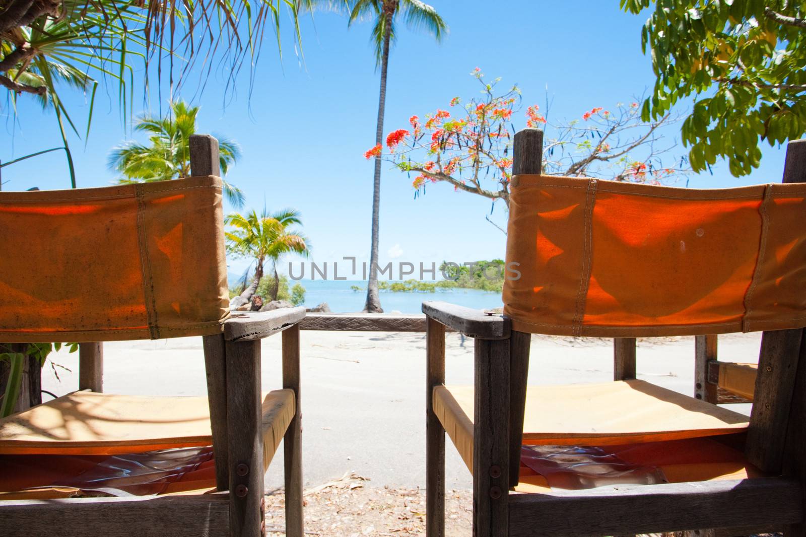 Two deck chairs overlooking a tropical beach by jrstock