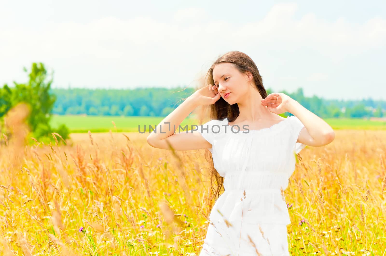 beautiful young Russian girl in a field with gold ears of wheat