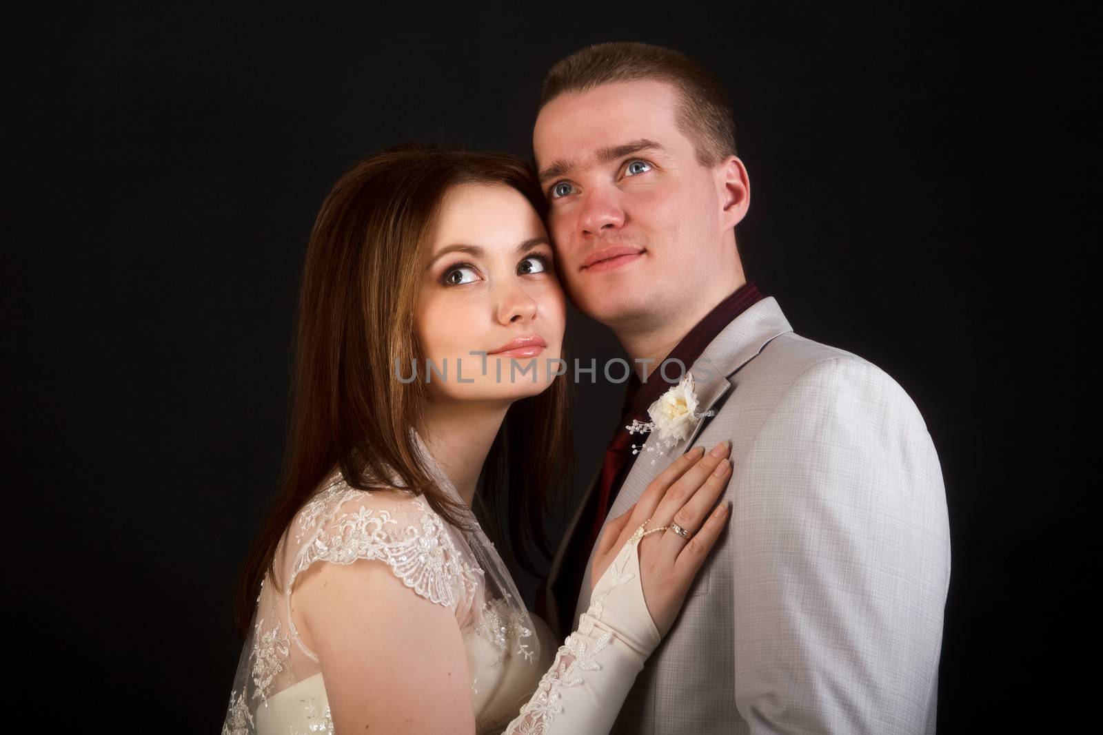 Happy romantic newlyweds on a black background