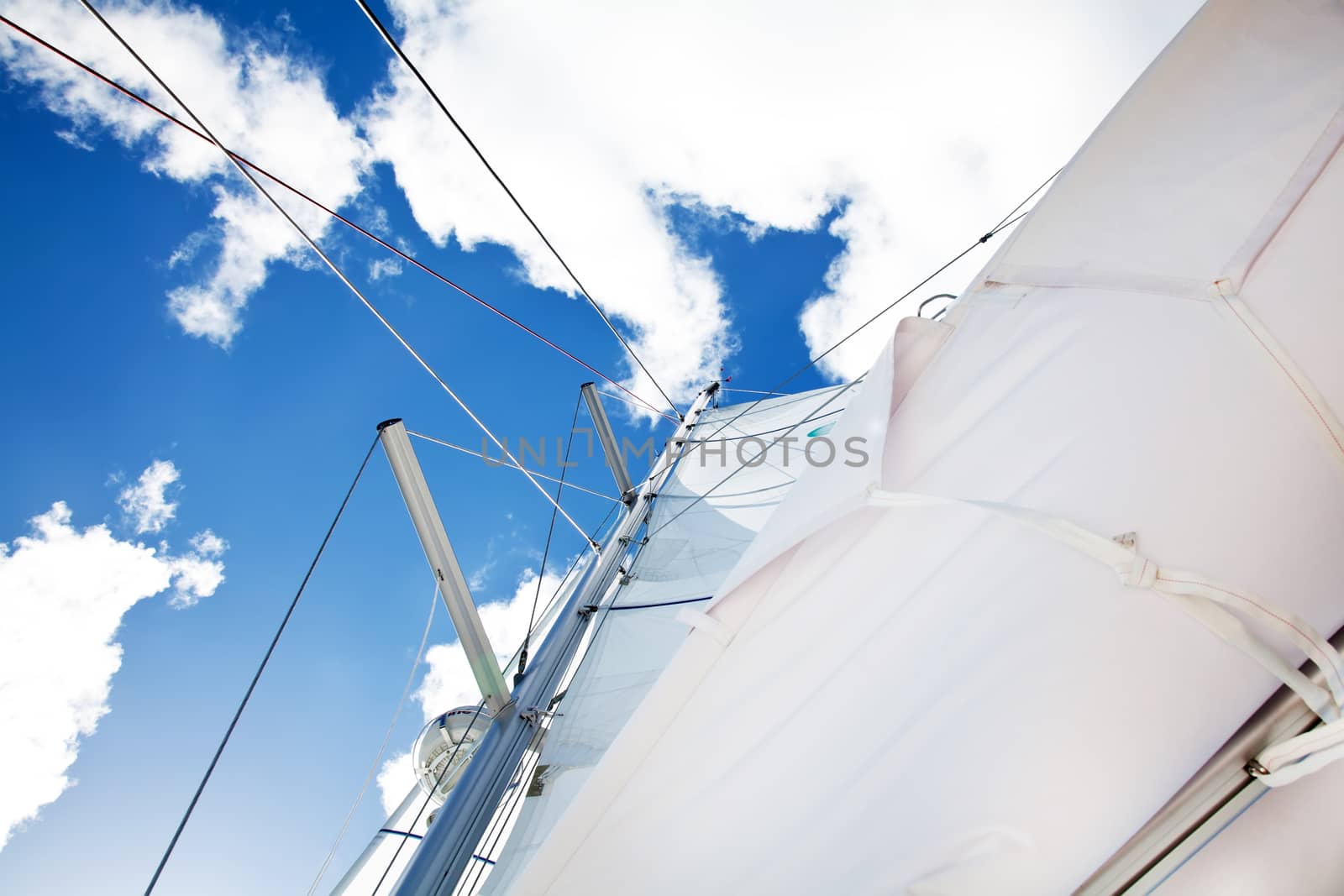 Sail of a sailing boat over bright bue sky 