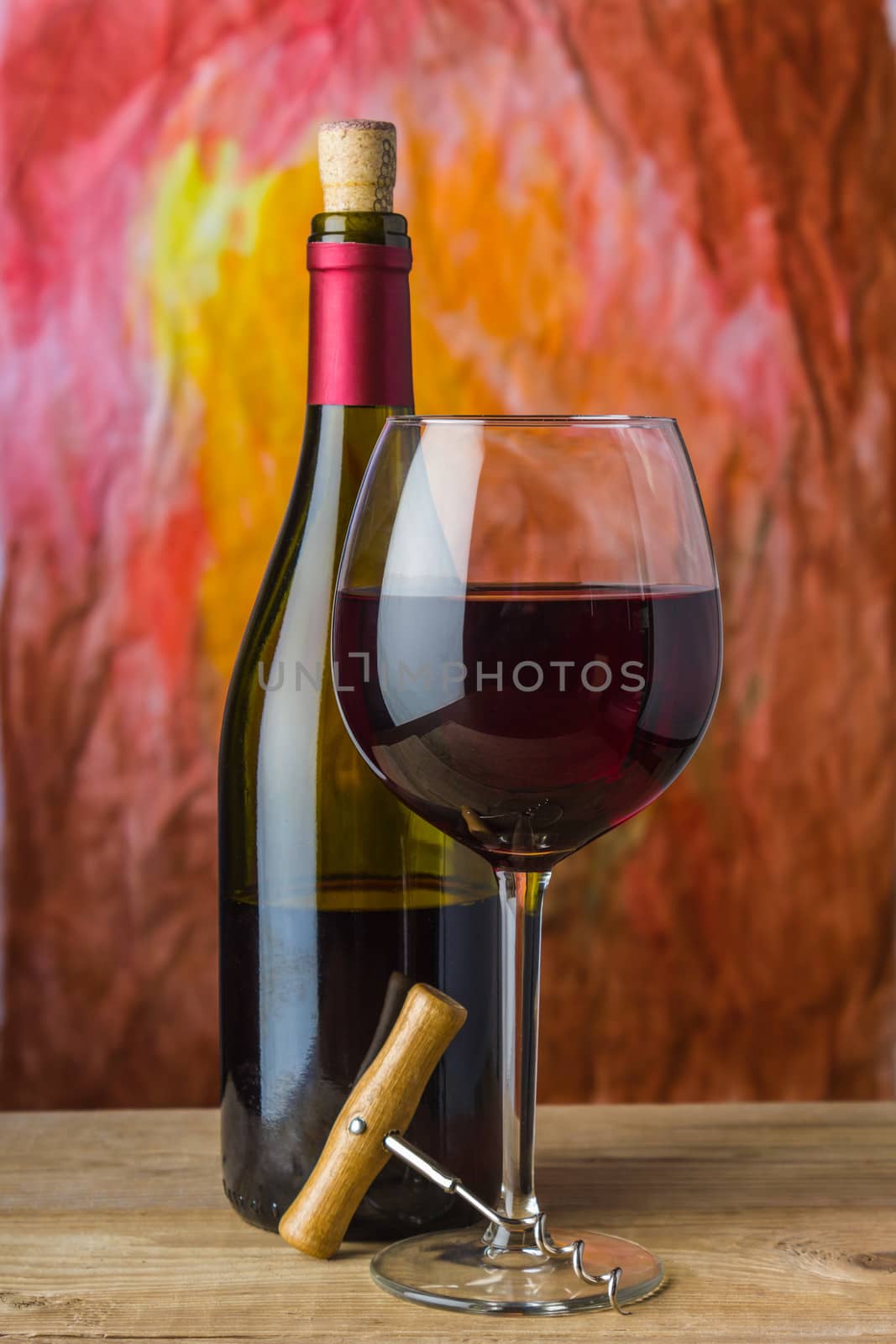 Wine, glass and the bottle on a colored background