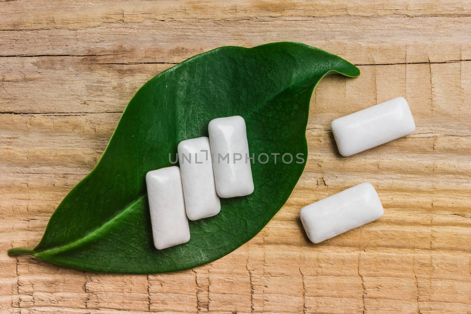 chewing gum is on a leaf on the background of wooden boards