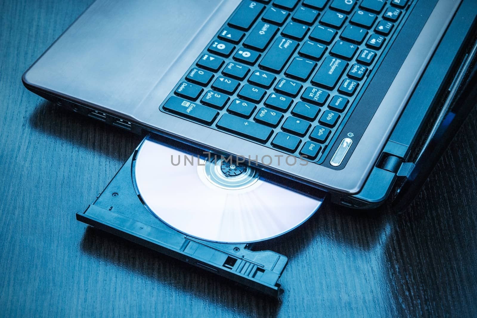 Laptop with open CD - DVD drive. Abstract light composition