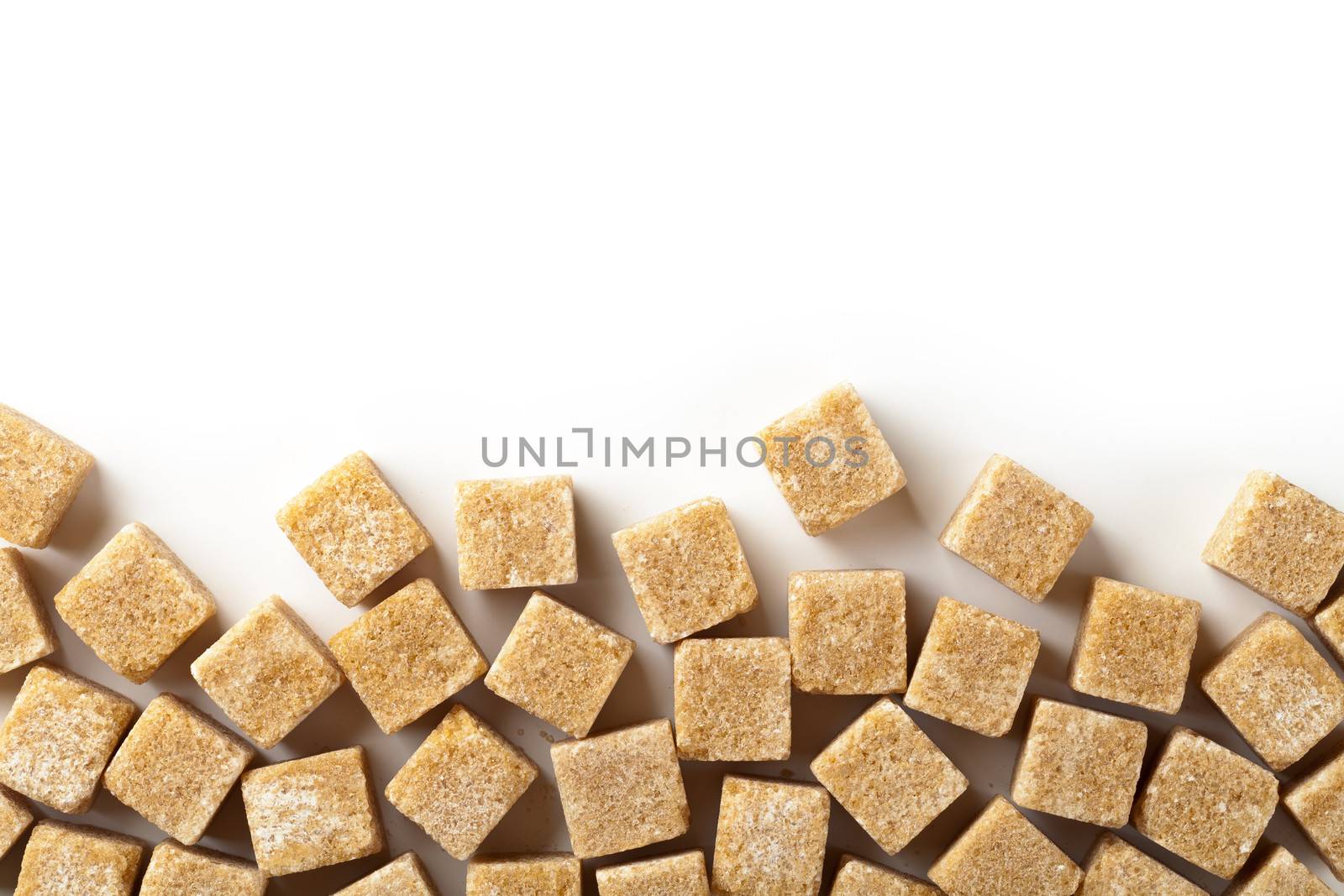 Brown sugar cubes on white background with copy space. Top view