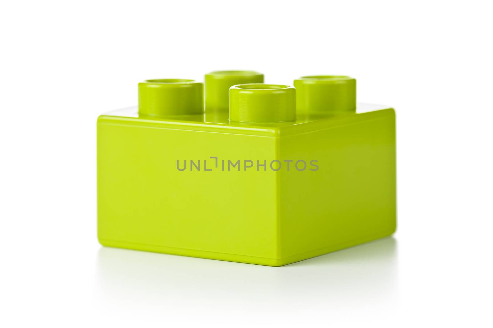 Plastic toy block, green color, on white background