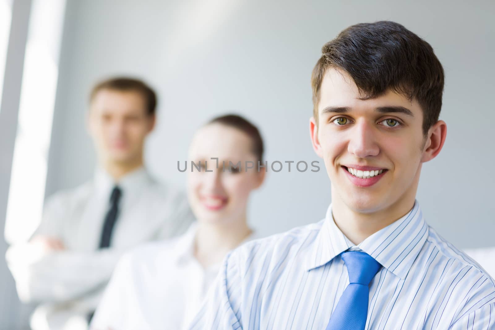 Smiling successful businessman with colleagues at background