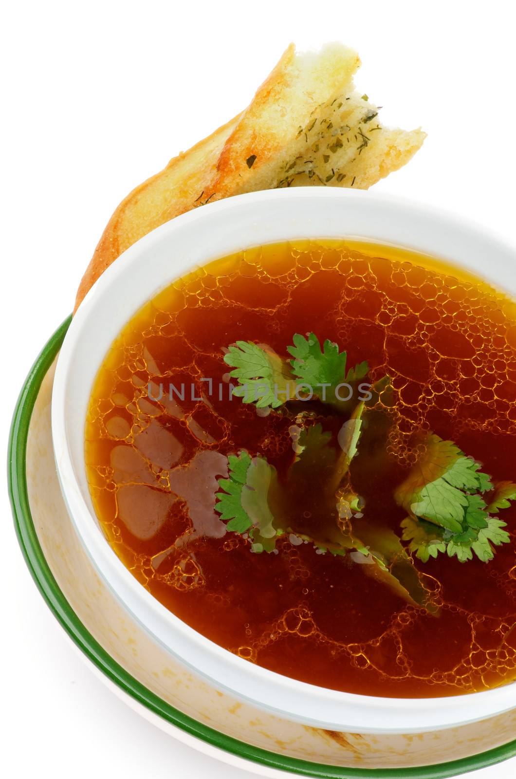 Useful Vegetables Bouillon with Parsley in Bowl with Garlic Bread isolated on white background