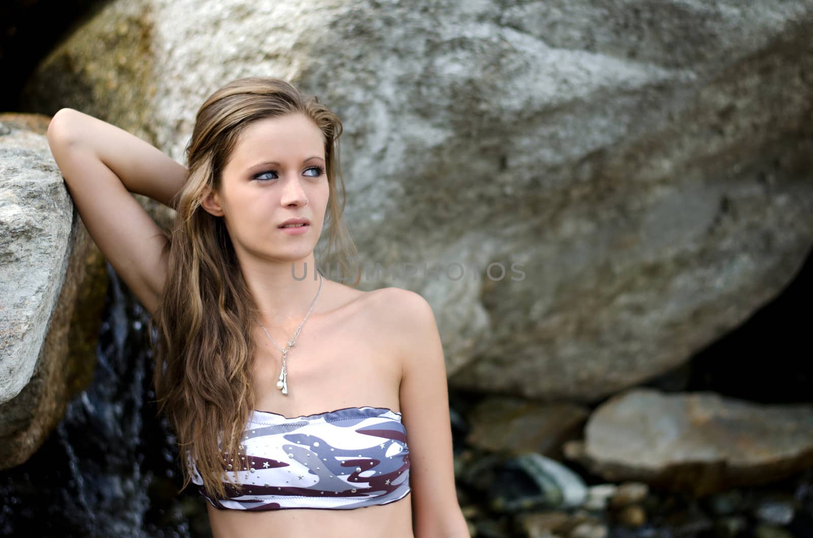 Pretty girl in bikini against rock by artofphoto