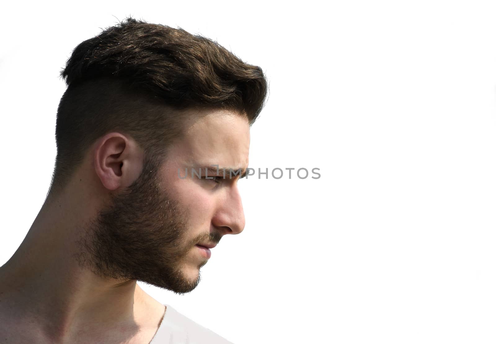 Portrait, profile shot of young man's face looking to a side, isolated on white