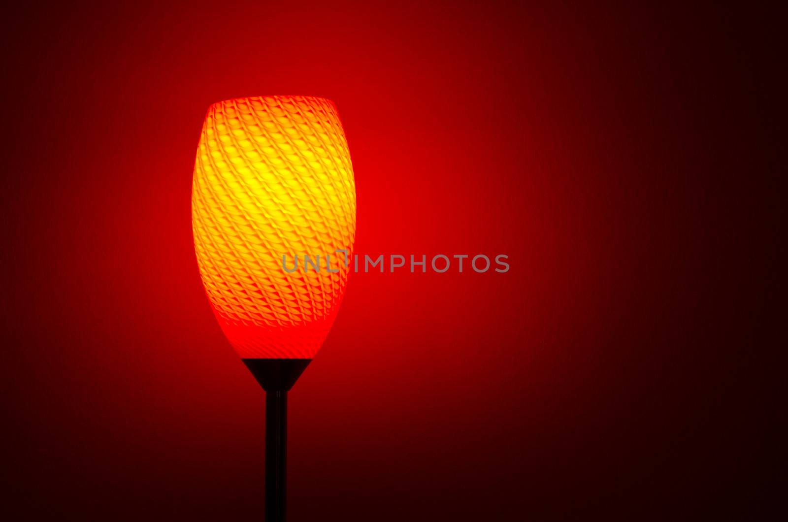 lamp shining red and orange color light with red wall in the background