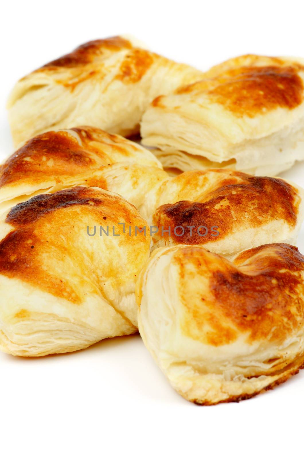 Fluffy Puff Pastry Bakery Bows In a Row isolated on white background. Selective Focus