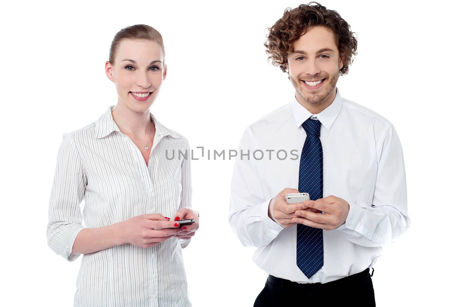 Cheerful office colleagues sending texts by stockyimages