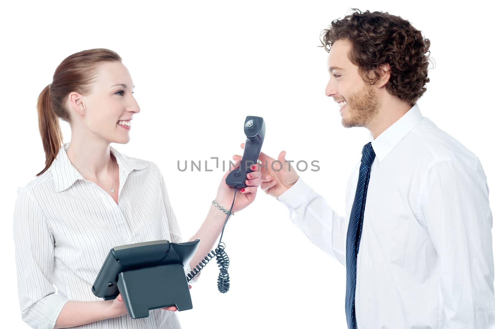 Secretary handing over phone receiver to her boss