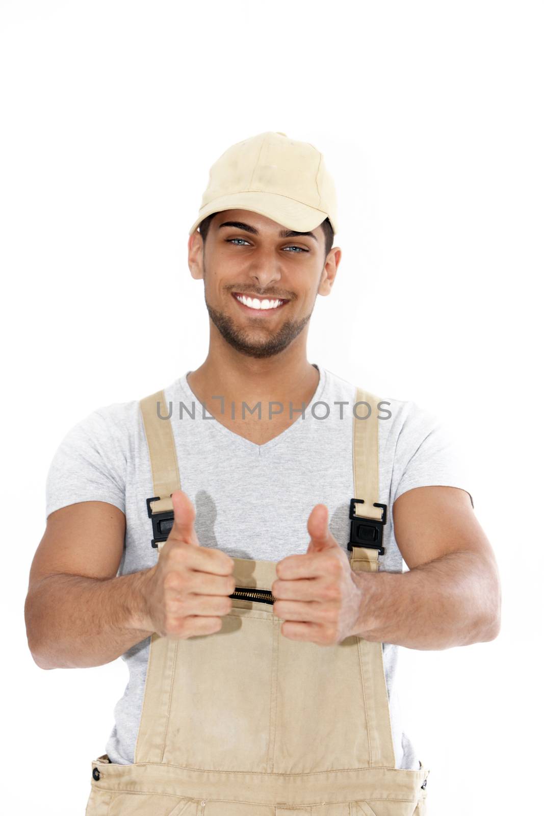 Handsome handyman with a big friendly smile giving a thumbs up of approval and success isolated on white