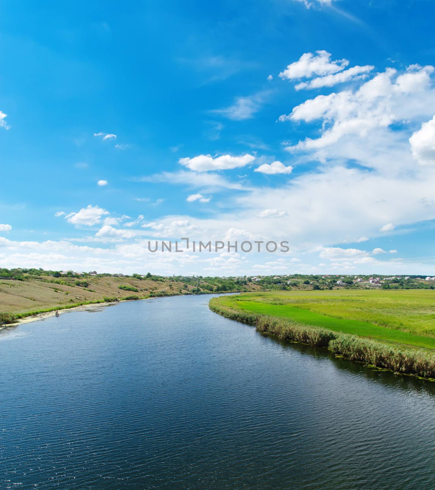 river with reflections and blue cloudy sky by mycola