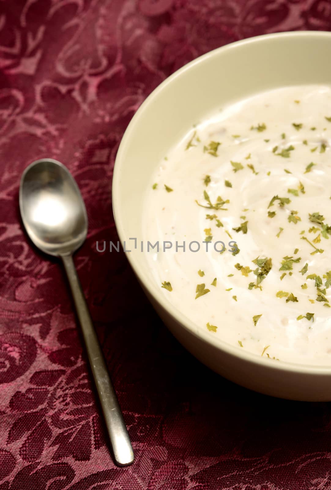 hot savory soup and spoon on burgundy 