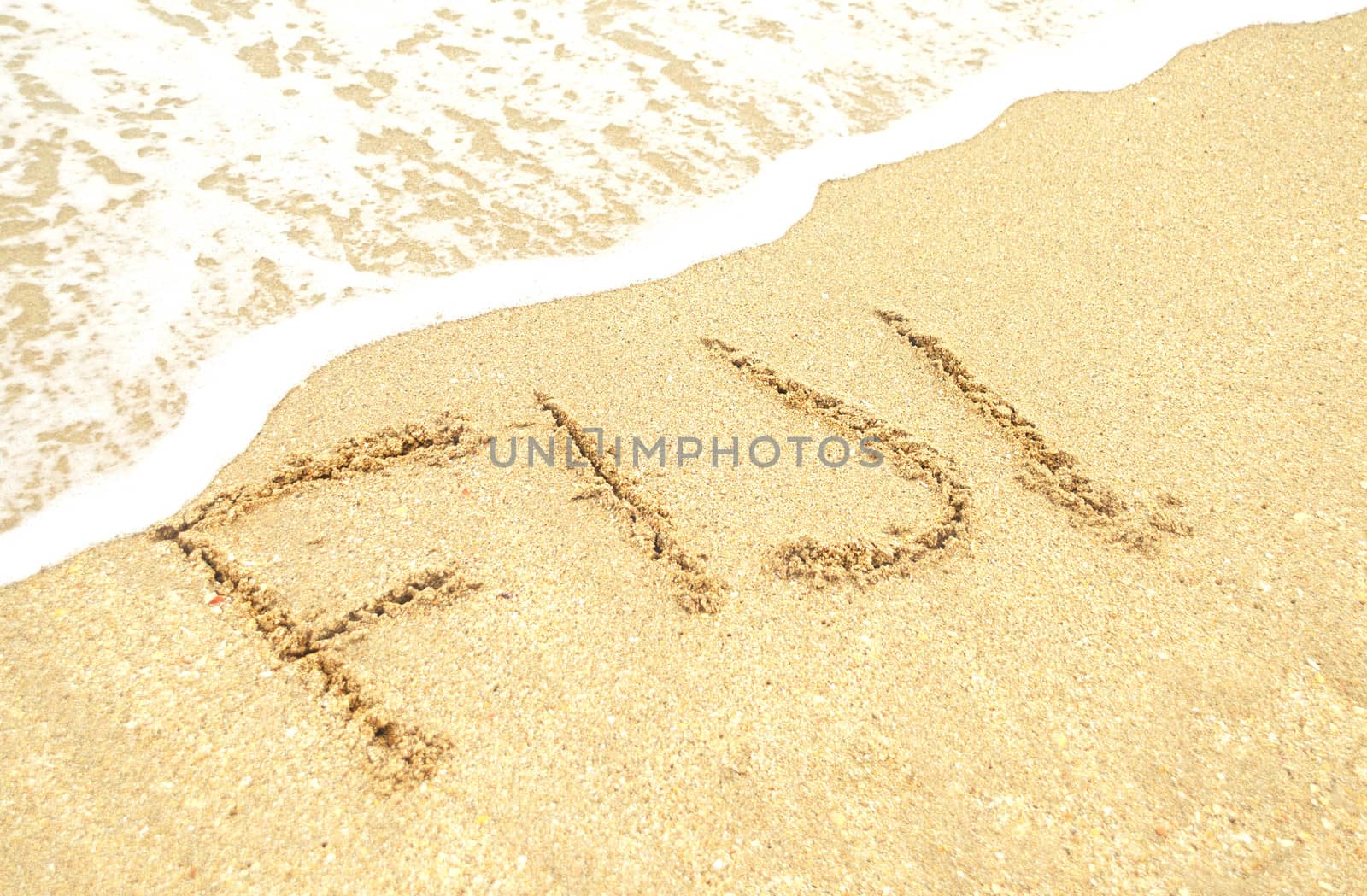 A warm tropical beach wand waves and Fiji written in the sand 