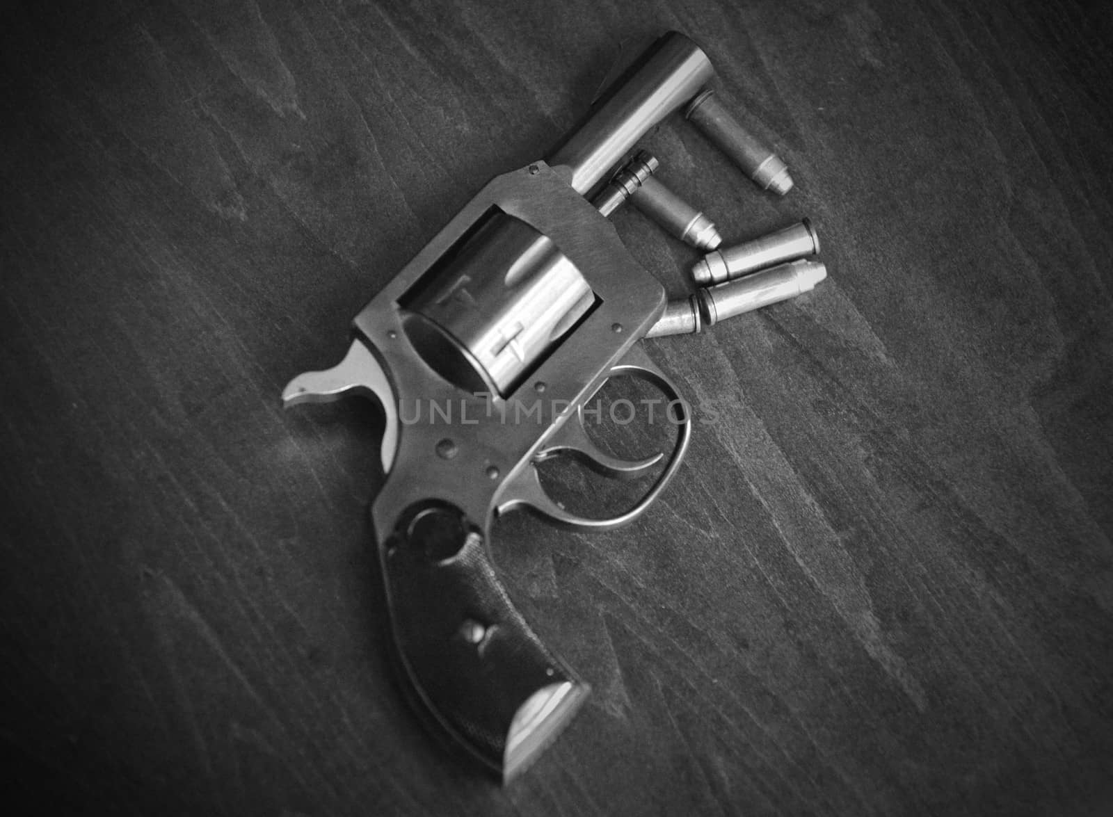 a black and white gun with bullets on wood background