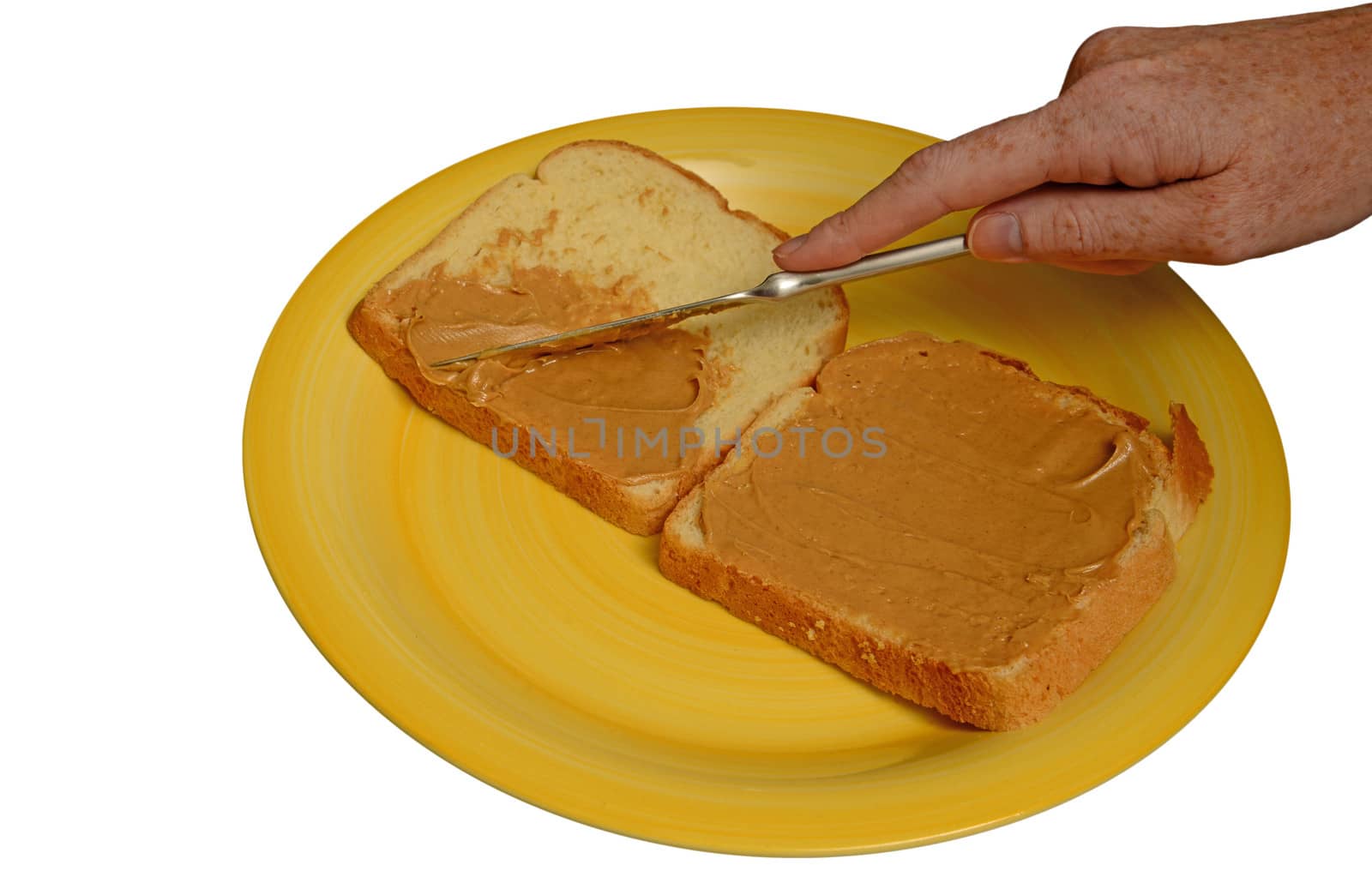 making a sandwich and spreading peanut butter on bread with knife