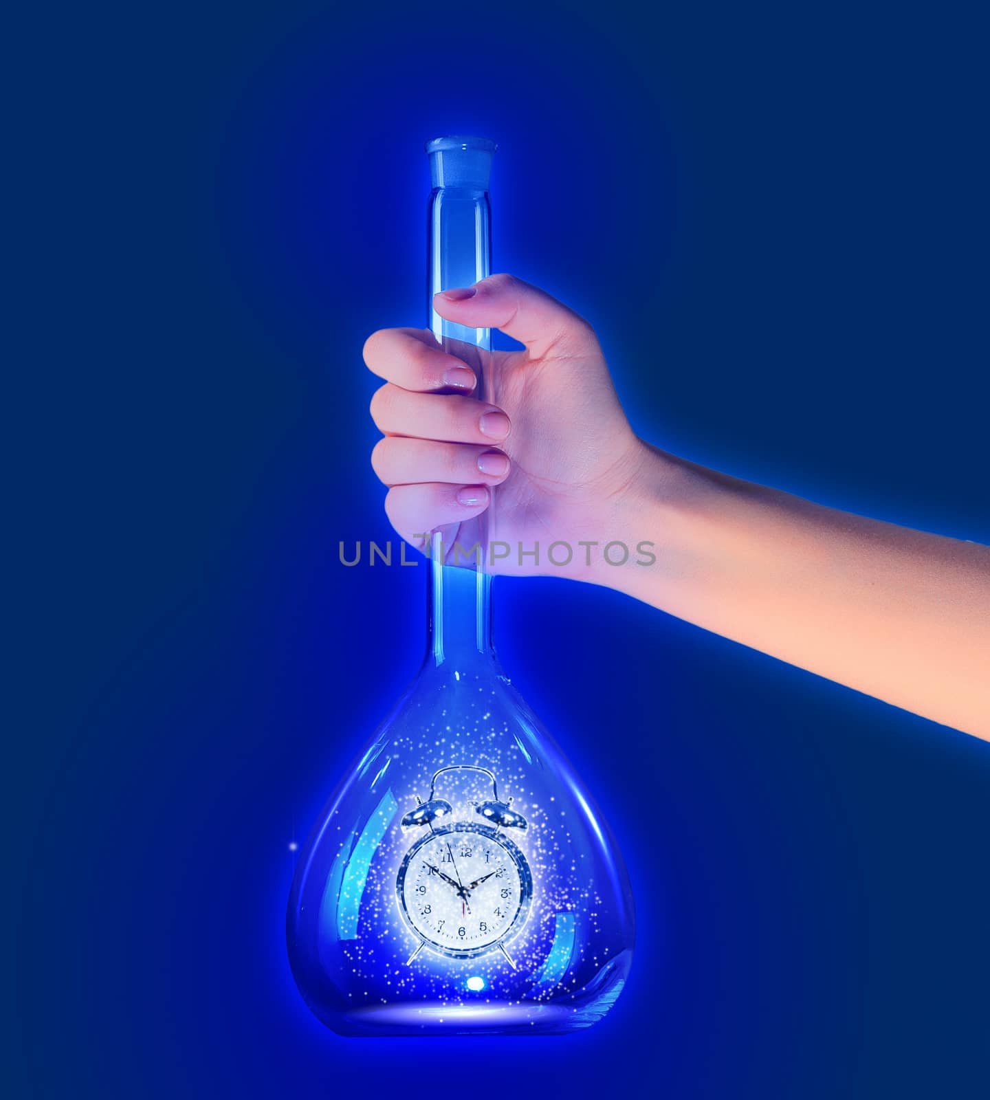 Human hand holding test tube with alarm clock inside