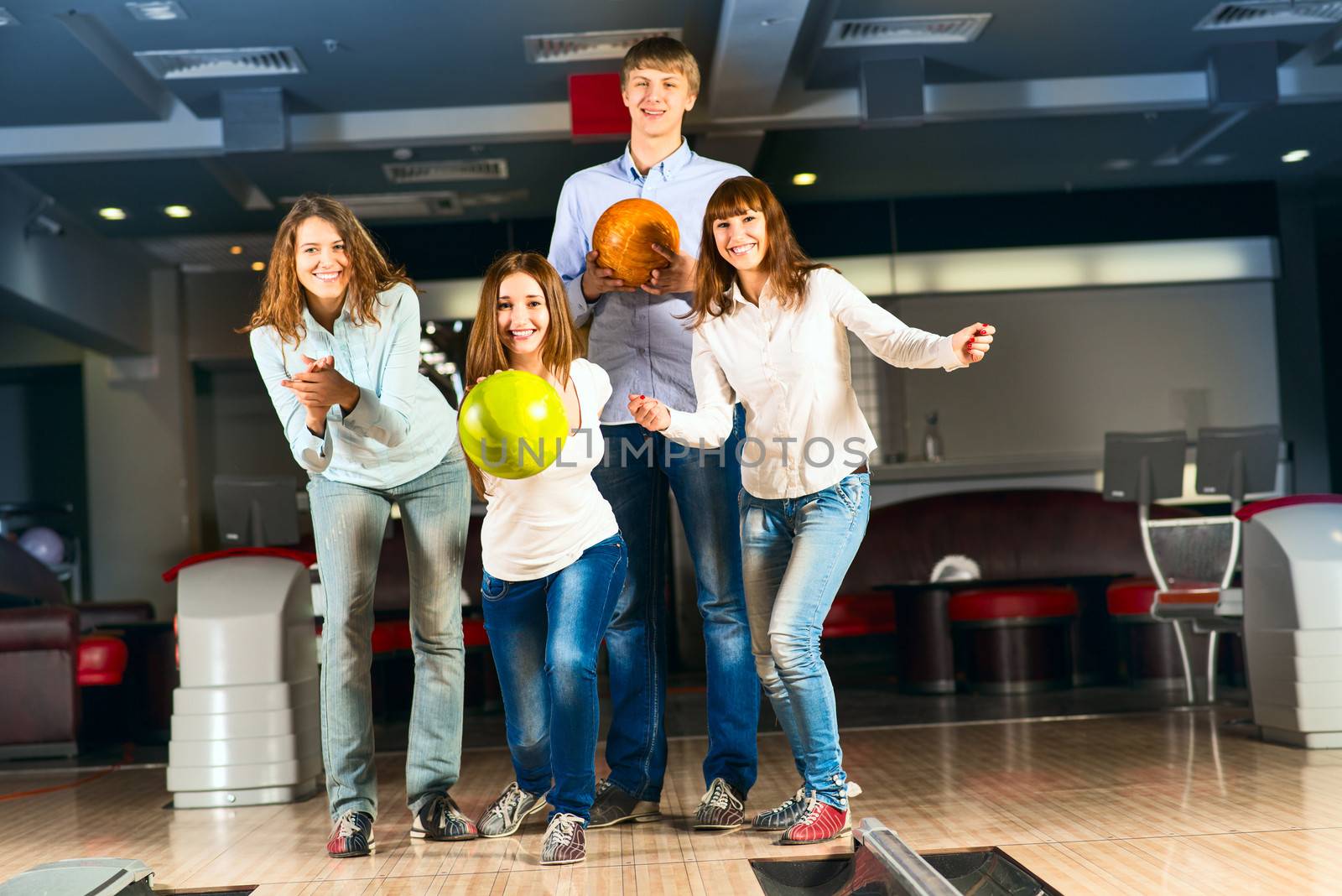 Group of young friends playing bowling, spending time with friends