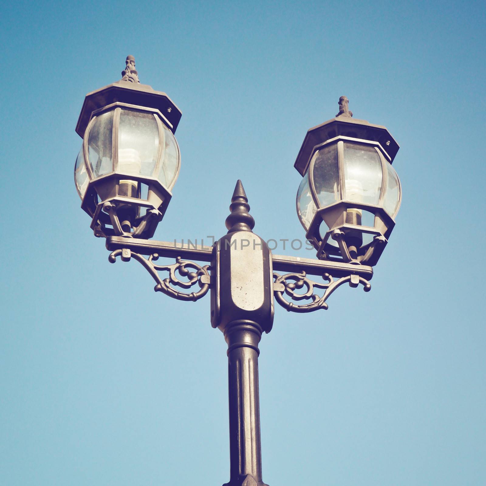 Old vintage street light against blue sky with retro filter effe by nuchylee